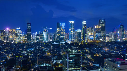 Illuminated cityscape against sky at night