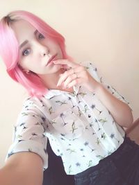 Portrait of woman against wall at home