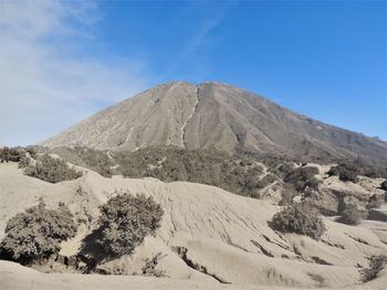 Scenic view of mountain against blue sky