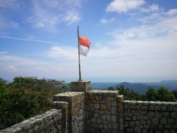 Flag by built structure against sky