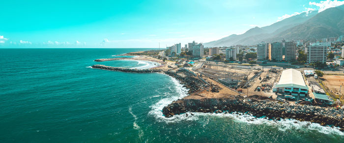 High angle view of townscape by sea against sky