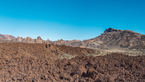 Scenic view of desert against blue sky