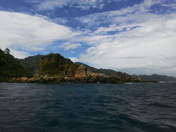 Scenic view of sea and mountains against sky