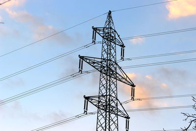 Low angle view of silhouette electricity pylon against sky