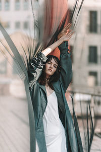 Young woman standing with umbrella against blurred background