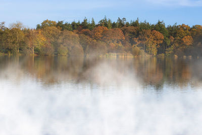 Scenic view of lake by trees against sky during autumn