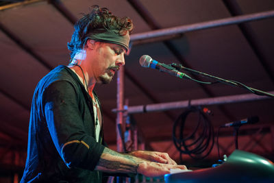 Side view of young man playing music at night