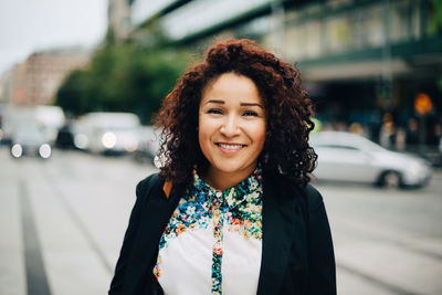 Portrait of smiling young woman in city