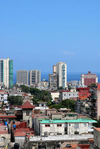 Bird eye view of buildings in city against clear blue sky