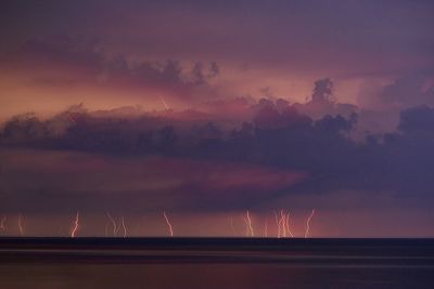 Scenic view of sea during thunderstorm with lots of lightning in the distance