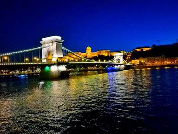 Suspension bridge over river at night