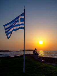 Lifeguard hut on beach against sky during sunset