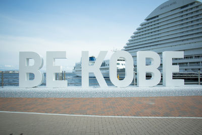 Text on wall of building against sky