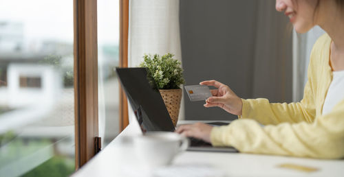 Midsection of woman doing online payment