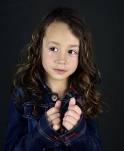 Portrait of woman against black background