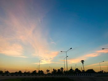 Silhouette street against sky during sunset