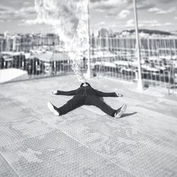 Man emitting smoke from mouth while lying on floor