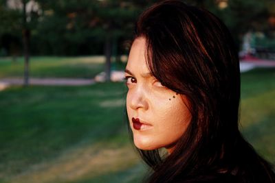 Close-up portrait of young woman with make-up at park