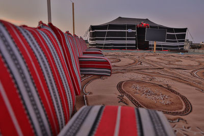 Empty seats in row at beach against sky