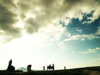 Silhouette of woman against cloudy sky