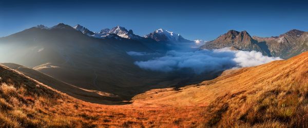 Panoramic view of snowcapped mountains against clear sky