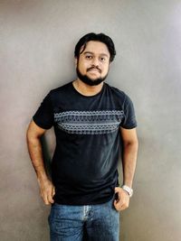 Portrait of man standing against wall