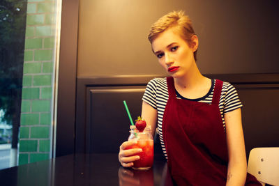 Portrait of young woman holding fruits