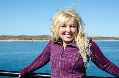 Portrait of smiling woman against sky