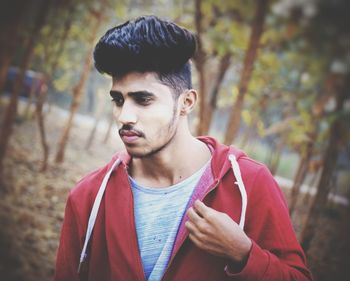 Portrait of young man looking away outdoors