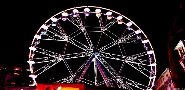 Low angle view of ferris wheel against sky at night