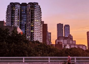 Modern buildings against sky during sunset