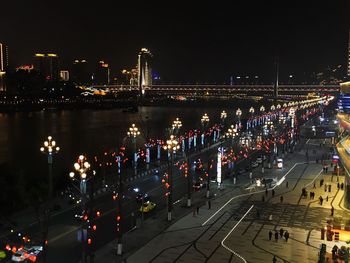 High angle view of illuminated city against sky at night