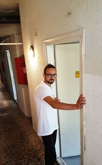 Man standing by text on wall