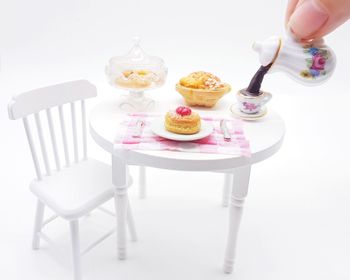 Close-up of hand holding ice cream cone on table