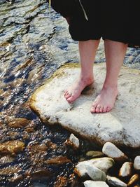 Low section of woman standing in water