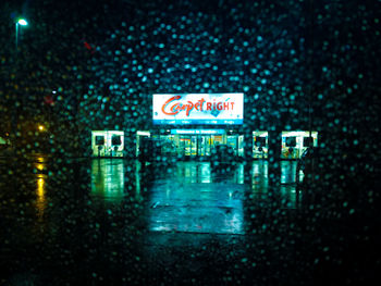 Road sign on wet street at night