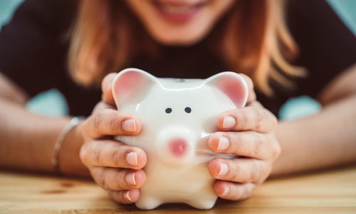 Close-up of woman holding piggy bank