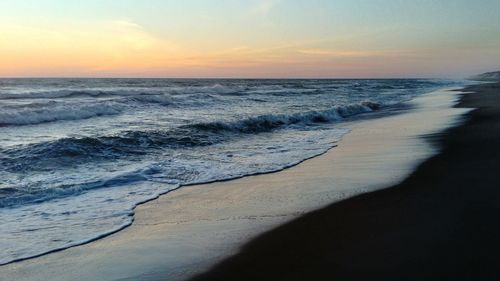 Scenic view of beach against sky during sunset