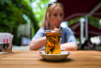 Portrait of woman with drink on table