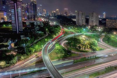High angle view of illuminated city street and buildings at night