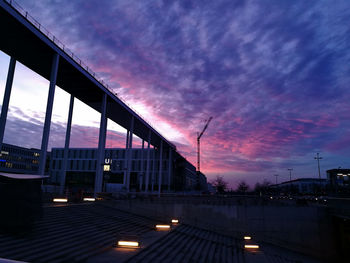 Low angle view of illuminated buildings against sky at sunset