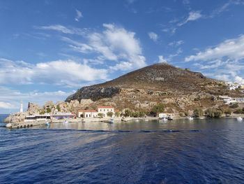 Scenic view of river in front of town against sky