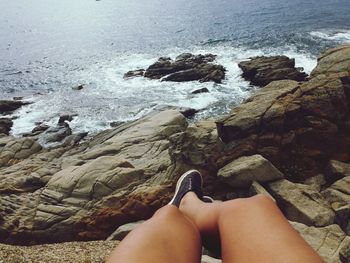 Woman lying on rocks at seaside