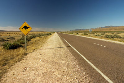 Road sign against clear sky