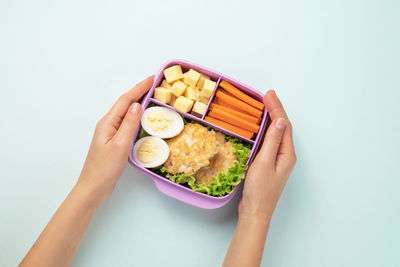 Midsection of person holding food against white background