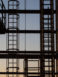 Low angle view of silhouettes of ladders against clear sky