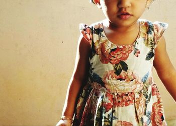 Midsection of girl standing against wall