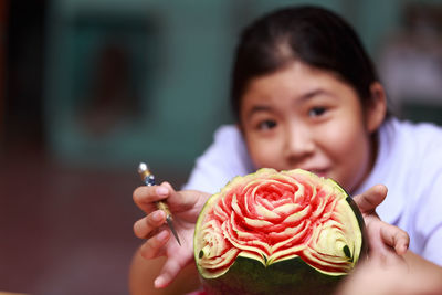 Portrait of skilled girl showing watermelon carving