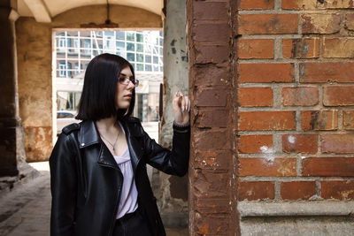 Woman standing against brick wall