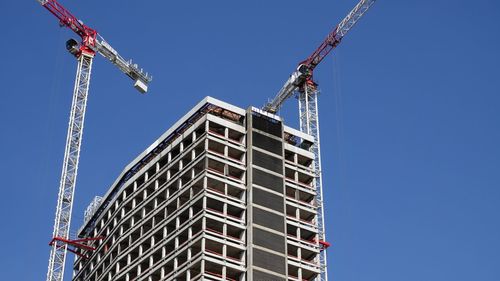 Low angle view of crane against clear sky